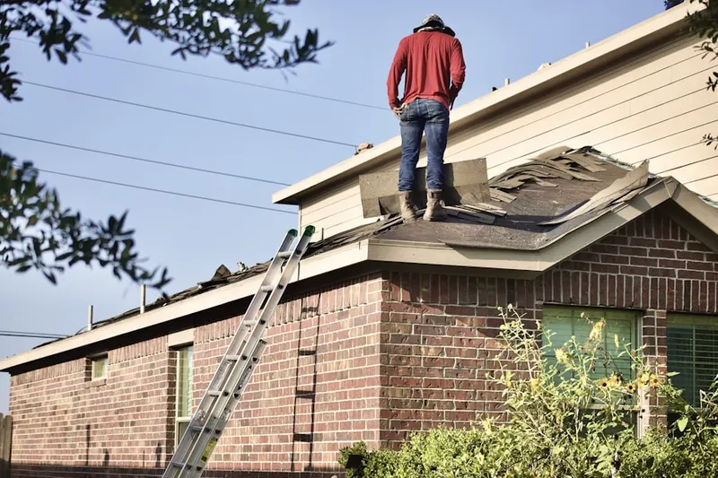 Professional roofer working on a residential roof in Elberta